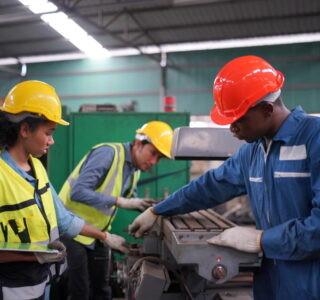 Três trabalhadores industriais tentando reduzir custos operacionais na indústria