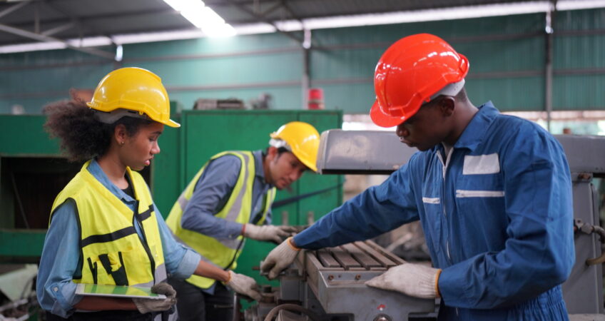 Três trabalhadores industriais tentando reduzir custos operacionais na indústria